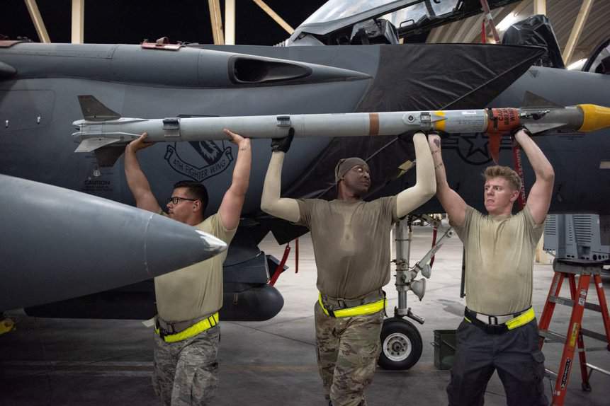 Des militaires de l'USAF chargeant un AIM-9X sur un chasseur-bombardier F-15E Strike Eagle. Photo : USAF.