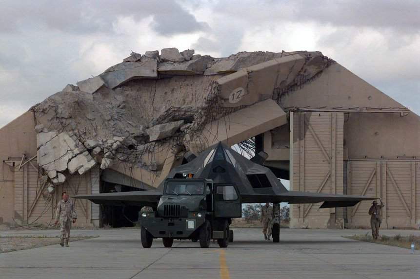 Um F-117 é rebocado na frente de um hangar reforçado destruído na Base Aérea de Ahmed Al-Jaber, no Kuwait, em 1998. Foto: A1C Greg L. Davis/USAF.