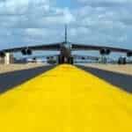 Imagem mostra bombardeiro americano B-52 visto de frente, com linha amarela levando até a aeronave.