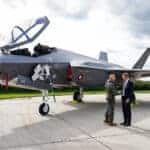Imagem mostra dois homens em frente a um dos quatro primeiros F-35 a chegarem na Dinamarca.